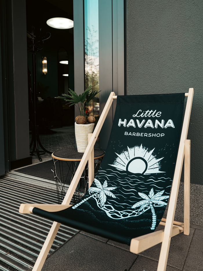 Firmowy leżak Little Havana Barbershop przed salonem