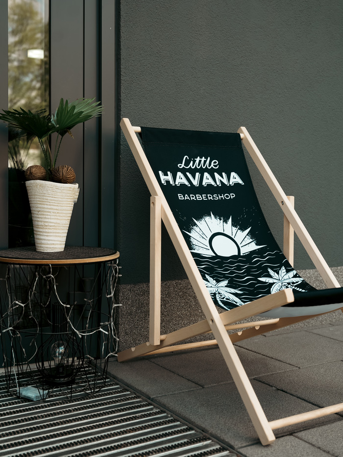 Firmowy leżak Little Havana Barbershop przed salonem